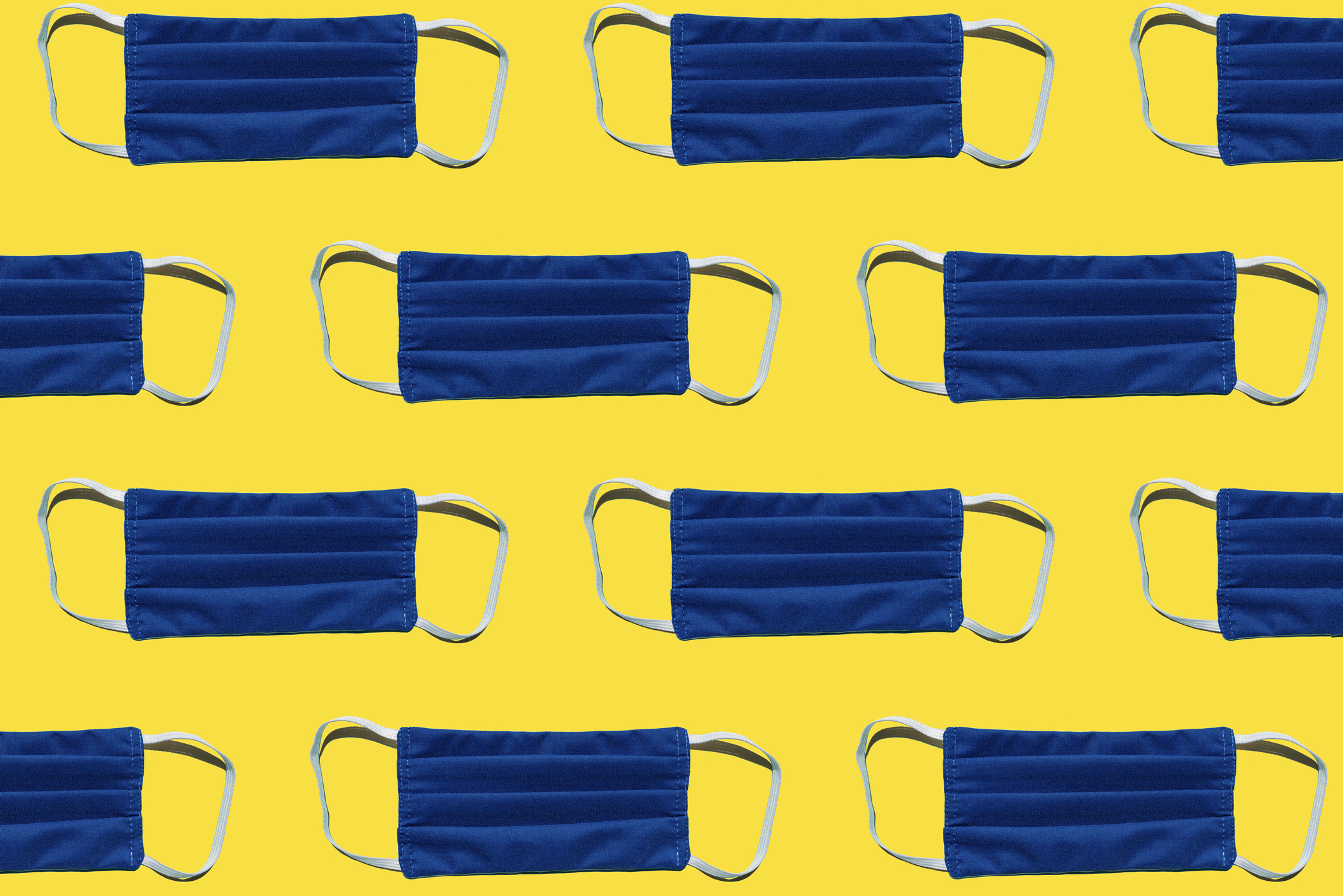 blue face masks on yellow background tiled